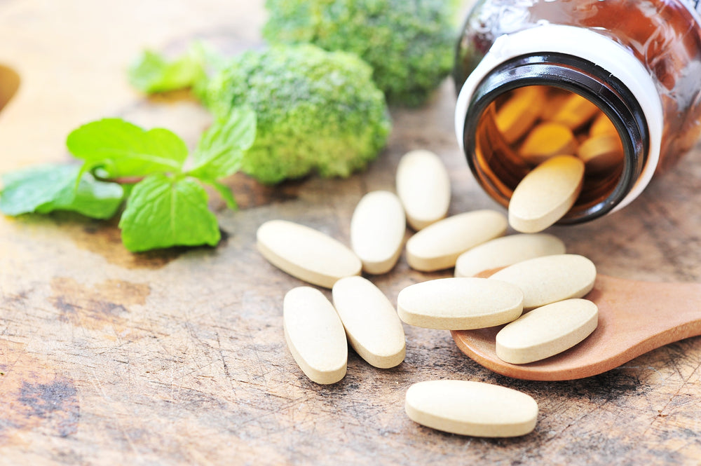 A bottle of vitamins next to vegetables. A. 