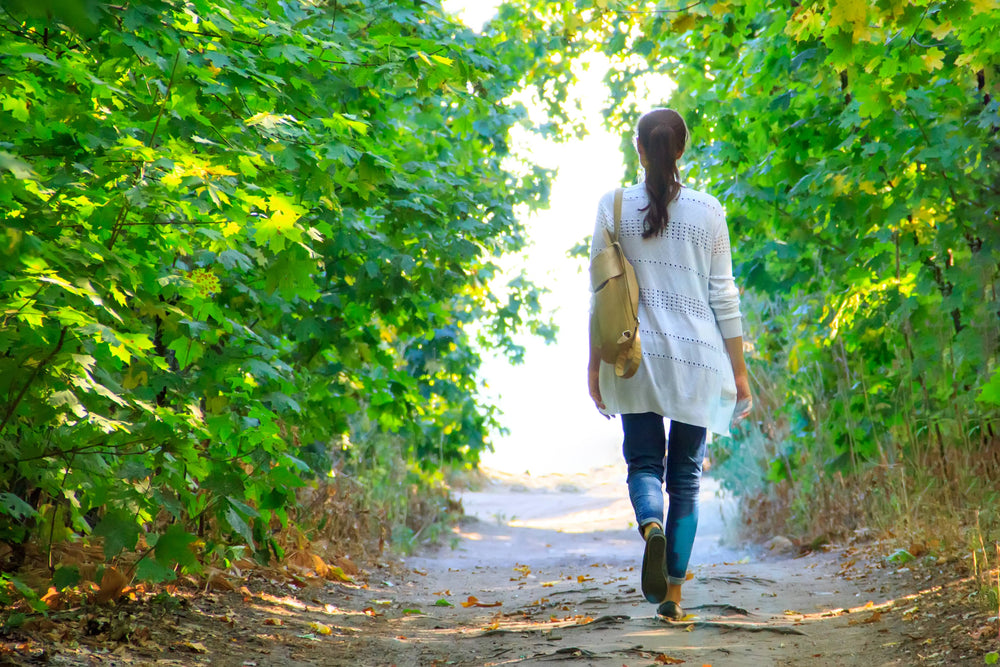 A woman walking on a trail A